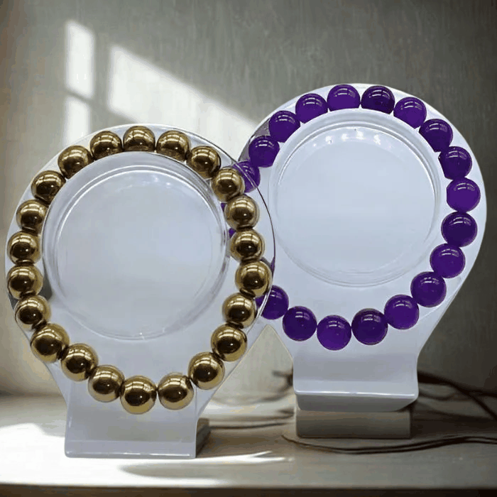 Elegant Purple and Gold Gemstone Bracelet Set featuring gold and purple spherical beads on display stands.