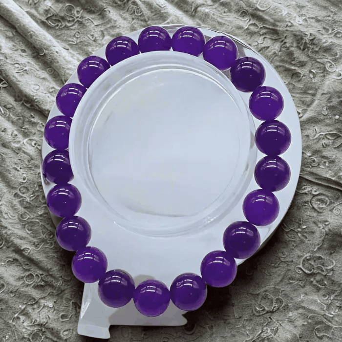 Elegant purple and gold gemstone bracelet with hematite and purple jade on display.
