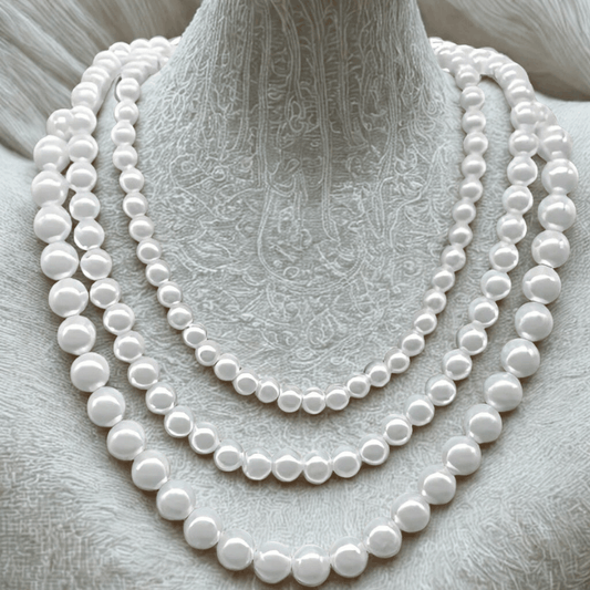 Classic Single Strand White Pearl Necklace with silver toggle clasp displayed on textured surface.
