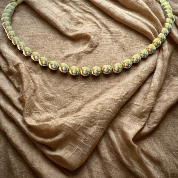 Gold Hematite Gemstone Necklace by Peace N Beads Design displayed on textured brown fabric