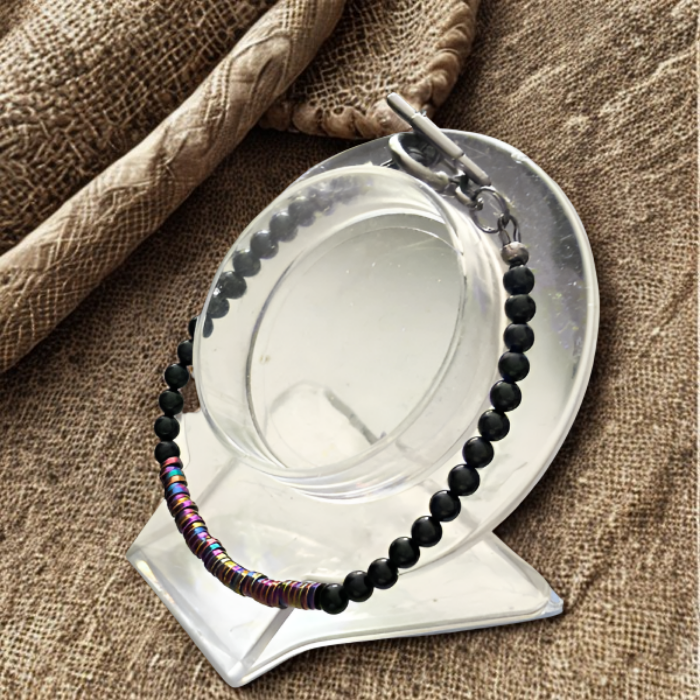 Rainbow Hematite and Black Onyx Protection Bracelet by Peace N Beads on a reflective display stand