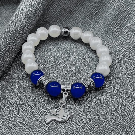 Blue Jade and White Glass Pearl Charm Bracelet with Bird Pendant on Fabric Background