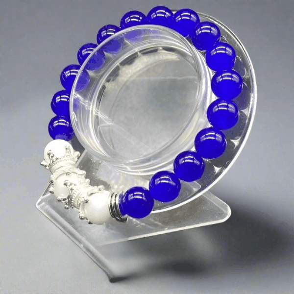 Crown Blue Jade Bracelet by Peace N Beads with vibrant blue and white beads on a clear display stand