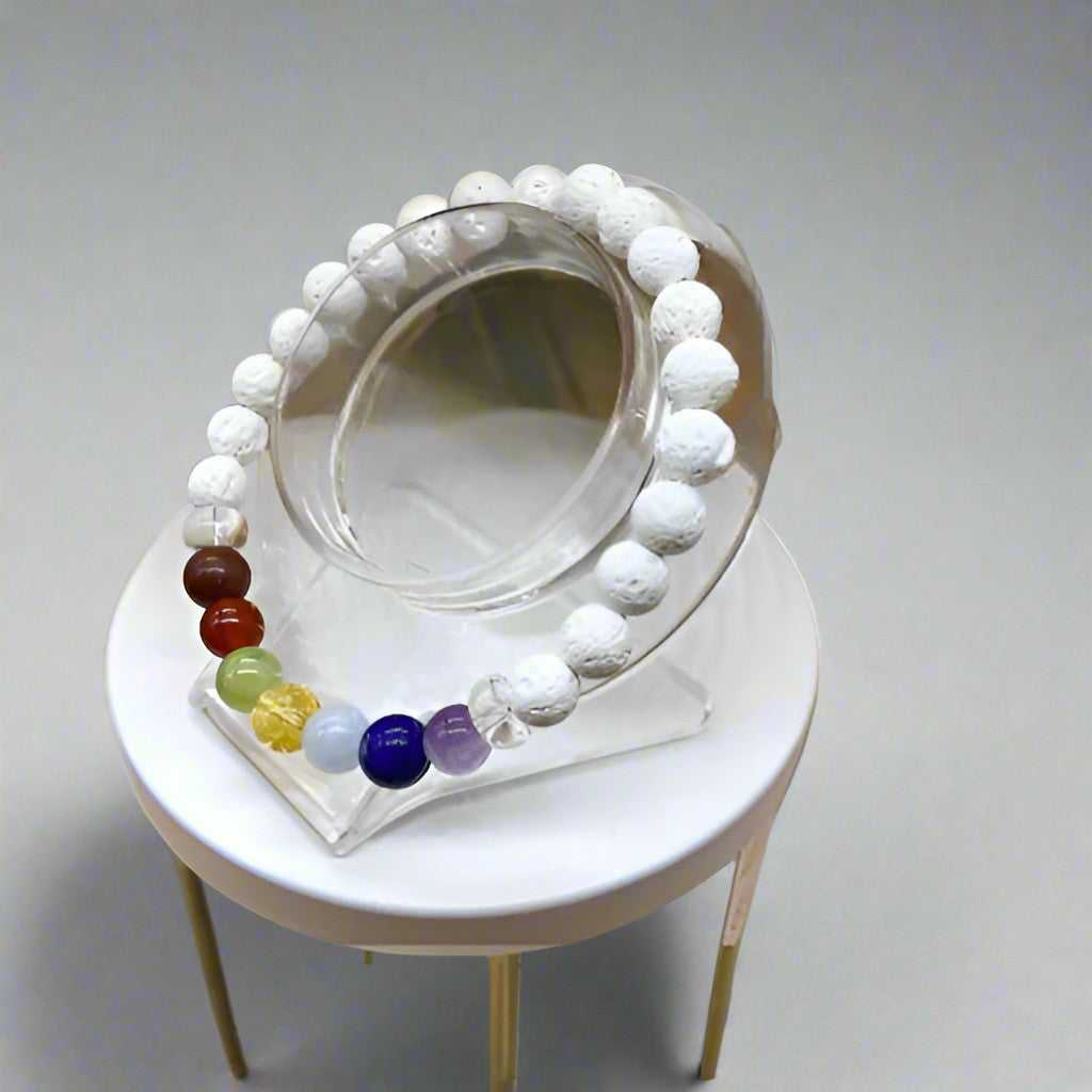 Peace N Beads Design 7 Bead White Lava Rock Chakra Bracelet displayed on clear stand with multicolor chakra beads