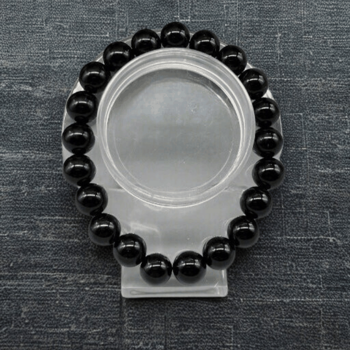 Elegant Black Onyx Gemstone Bracelet with polished beads on a display stand