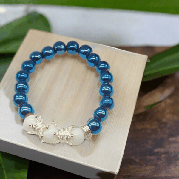 Crown Blue Hematite Gemstone Bracelet with shiny blue beads and silver crown accents on white beads