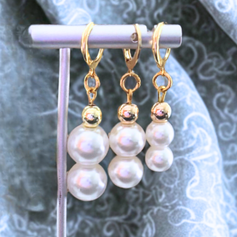 Elegant Pearl 2 Drop Earrings with gold accents displayed on a silver stand by Peace N Beads Design