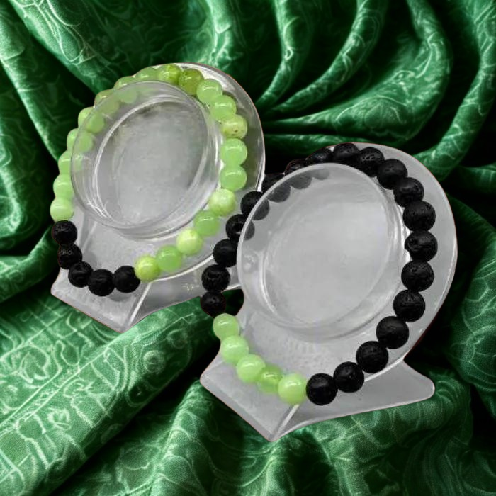 Heart Chakra Bracelets featuring green and black beads displayed on elegant stands