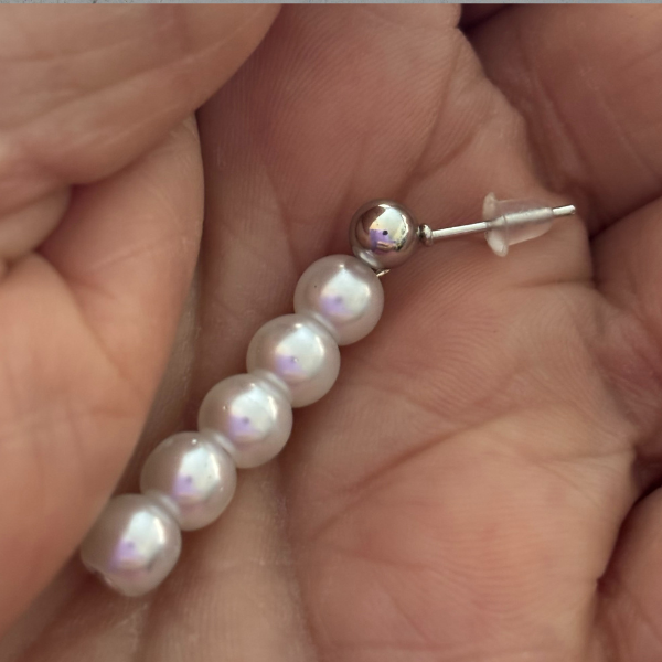 Peace N Beads Long Stud Drop Earrings featuring a row of five white pearls held in palm