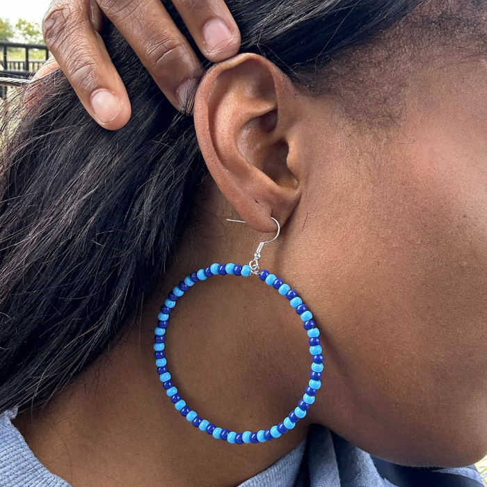 Sky and Royal Blue Medium Hoop Earrings displayed on a model's ear showcasing vibrant bead design