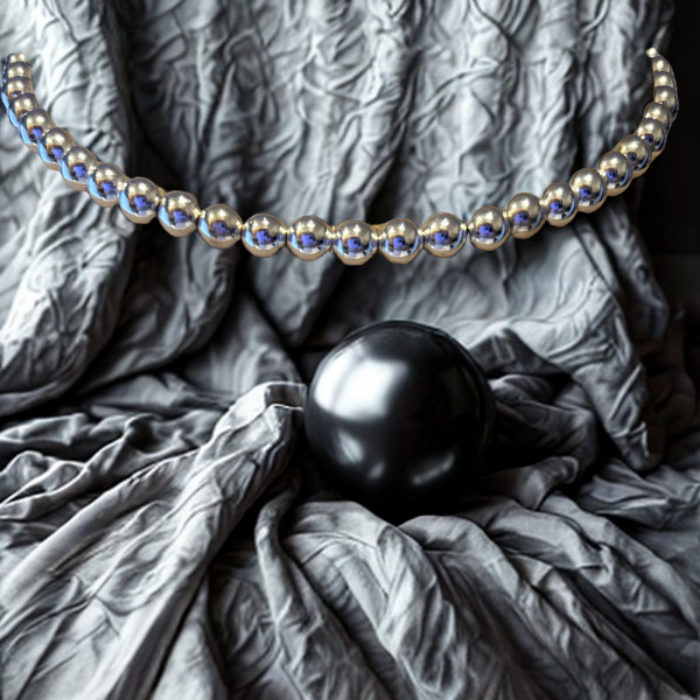 The Connection of Silver Hematite Necklace by Peace N Beads Design displayed on textured gray fabric with a black sphere