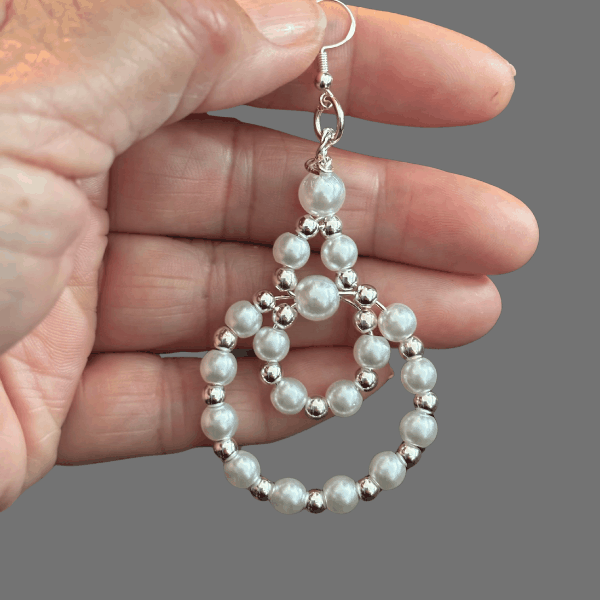 White Pearls with Silver or Gold Earrings held by hand featuring two connected pearl loops
