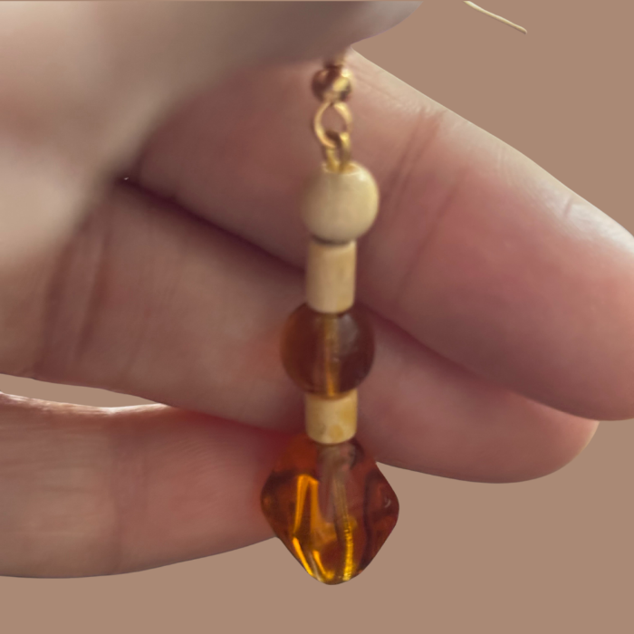 Wood and Orange Glass Drop Earrings by Peace N Beads Design held in hand showing wooden beads and orange glass detail