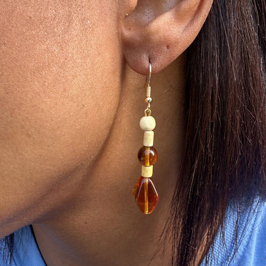 Wood and Orange Glass Drop Earrings by Peace N Beads Design worn on ear with wooden beads and orange glass accents