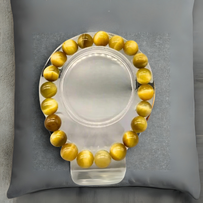 Genuine Golden Tiger Eye Gemstone Bracelet displayed elegantly on a clear stand