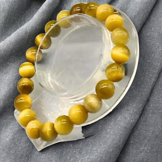 Genuine Golden Tiger Eye Gemstone Bracelet displayed on a clear stand against a gray background