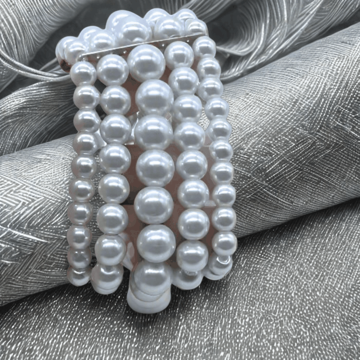 Multi Strand White Glass Pearl Stretch Bracelet with five intertwined strands on silky background.