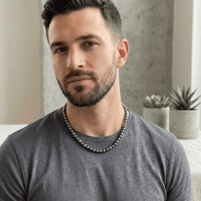 Man wearing a Bohemian Dream Rainbow Hematite Necklace, showcasing stylish bead design and adjustable fit