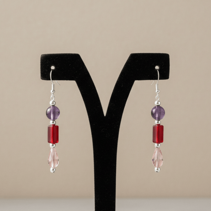 Crimson Elegance Red Hue Drop Earrings with purple and pink beads on a black display stand