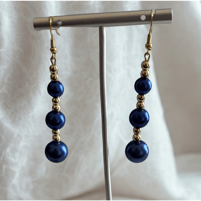 Elegant Hematite and Blue Glass Pearl Drop Earrings with gold accents on display