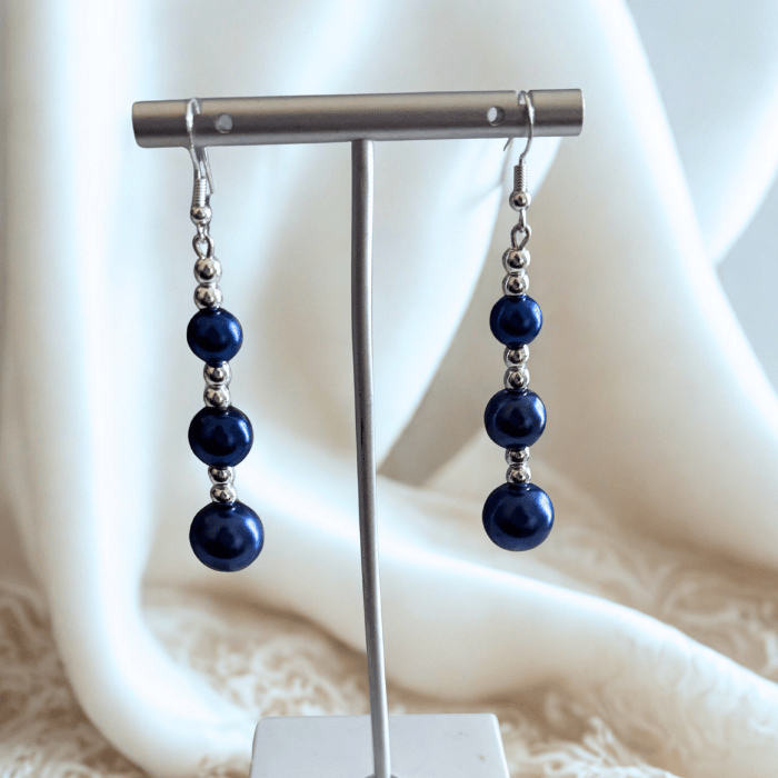 Elegant Hematite and Blue Glass Pearl Drop Earrings displayed on a stand with soft fabric backdrop