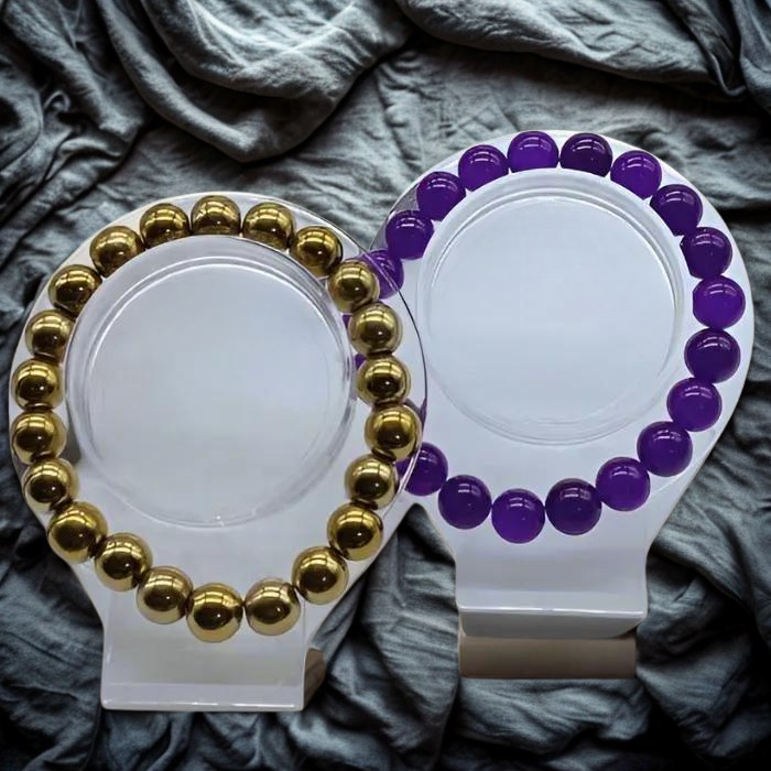 Elegant Purple and Gold Gemstone Bracelet Set displayed on a stylish stand against a textured background