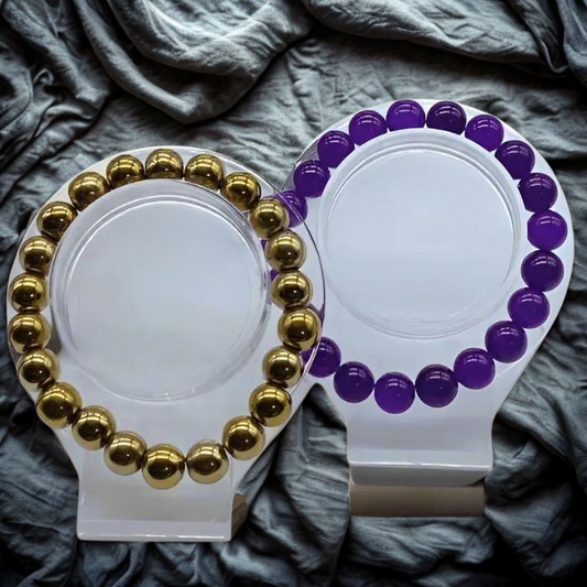 Elegant Purple and Gold Gemstone Bracelet Set displayed on a stylish stand against a textured background