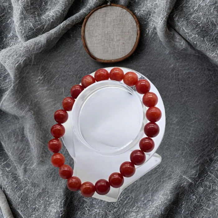 Elevate Your Style with the Red Coral and Cream Fossil Bracelet Set displayed on a stand