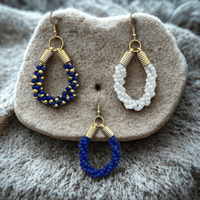 Gold Accented Twisted Royal Blue and Gold Hoop Earrings displayed on a textured stone surface