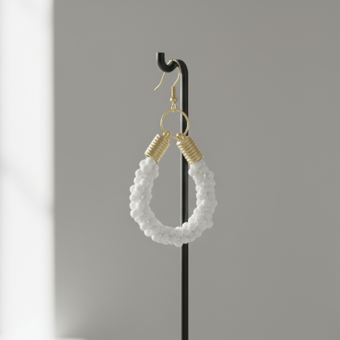 Gold Accented Twisted Royal Blue and Gold Hoop Earrings with a stylish design showcased on a display stand