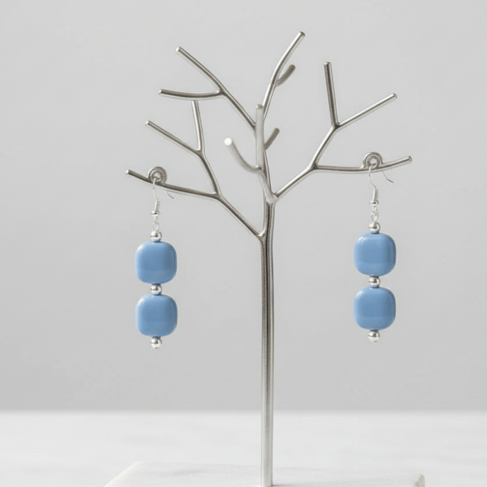 Light Blue and White Drop Earrings displayed on a silver tree stand, showcasing modern design