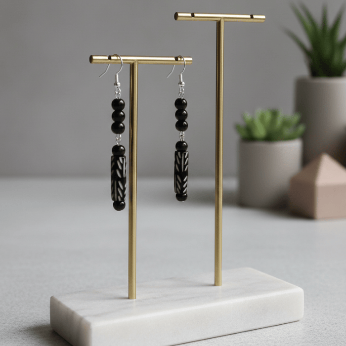 Black Onyx and Wood Drop Earrings displayed on a minimalistic stand