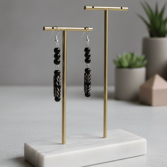 Black Onyx and Wood Drop Earrings displayed on a minimalistic stand