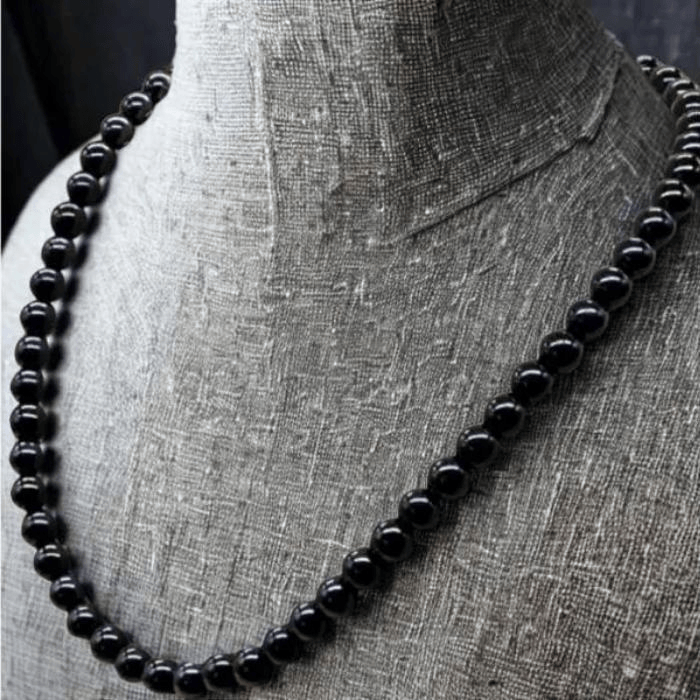 Elegant Black Onyx Jewelry Set featuring a smooth bead necklace displayed on a textured bust
