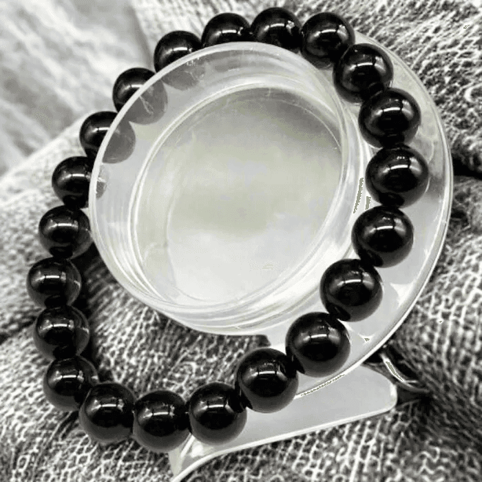 Elegant Black Onyx Protection Bracelet on display surrounded by grey fabric