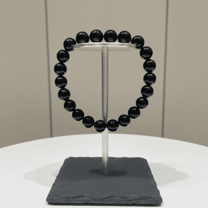 Black Onyx Protection Bracelet displayed on a metal stand for elegant showcase
