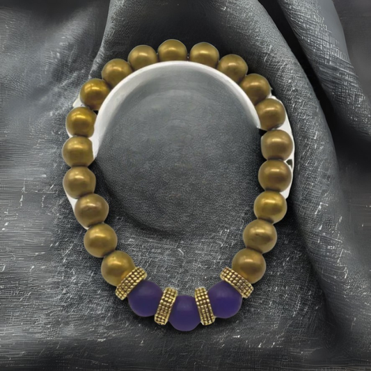 Bold Matted Gold Hematite Purple Jade Bracelet with Beads and Decorative Spacers on a Black Background