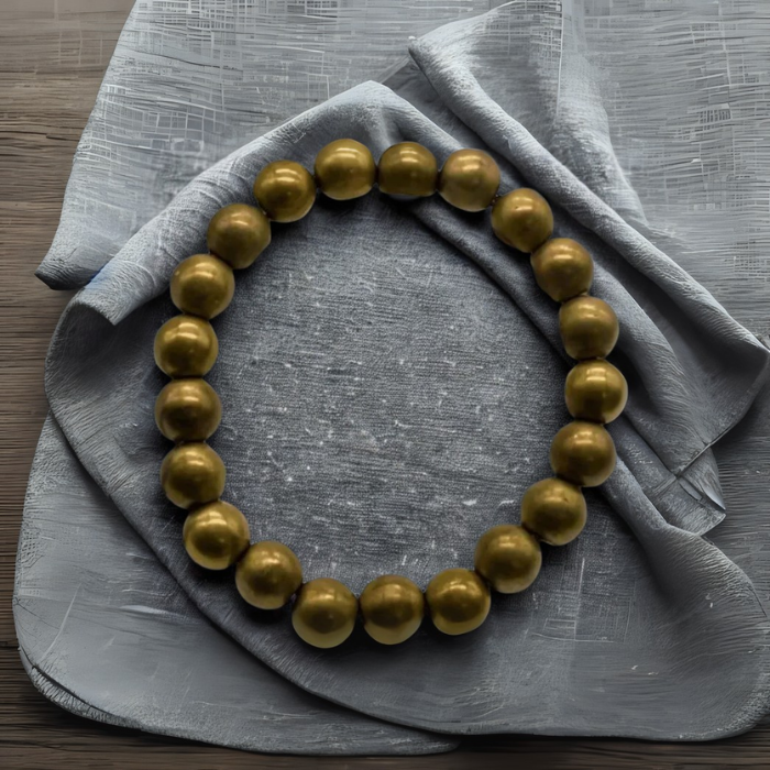 Dignified Double Protection Bracelets in gold with a smooth finish on a gray fabric background