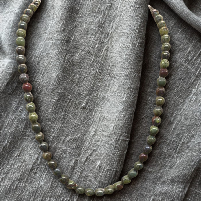 Dragon Blood Gemstone Necklace featuring colorful round beads on a textured gray background