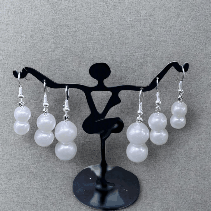 Elegant Pearl 2 Drop Earrings by Peace N Beads Design displayed on black dancer-shaped stand