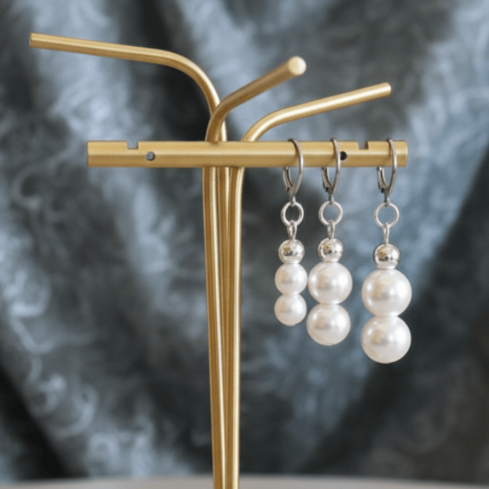 Stunning Elegant Pearl 2 Drop Earrings displayed on a gold jewelry stand