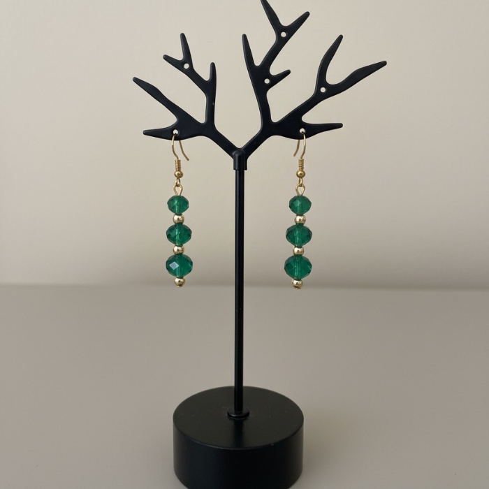 Elegant Emerald and Gold Drop Earrings with sparkling green crystals on a display stand