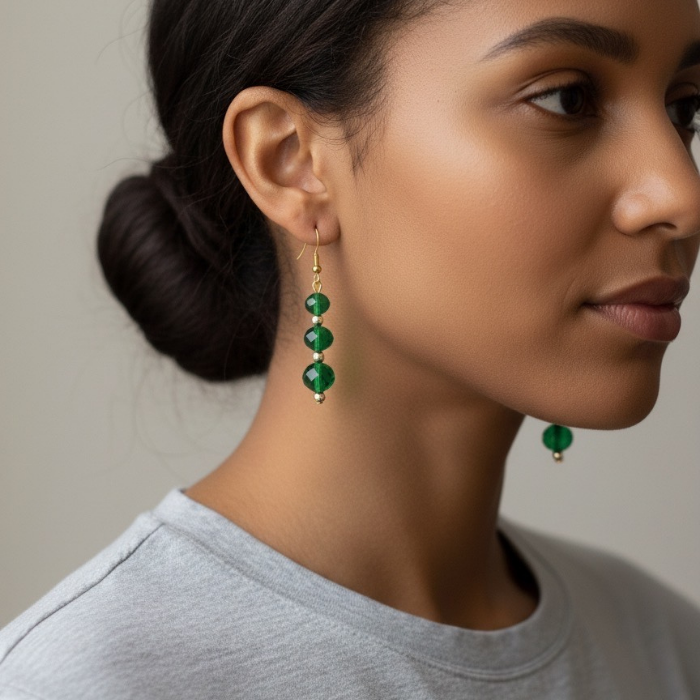 Emerald and Gold Drop Earrings on a model showcasing stylish elegance and sophistication
