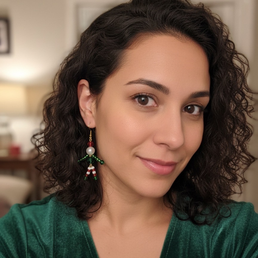 Model showcasing Enchanted Elf Earrings with green and red bead accents and pearl details