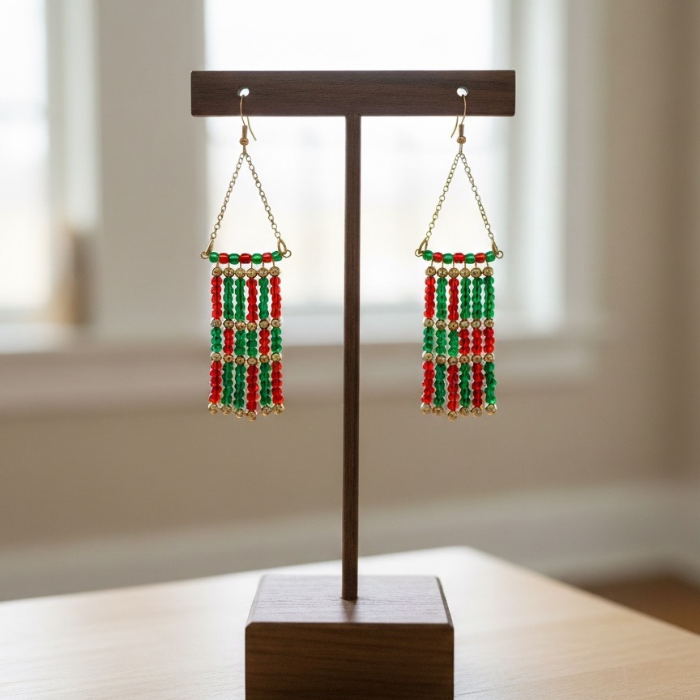 Colorful festive seed bead drop earrings in red and green hanging on a display stand