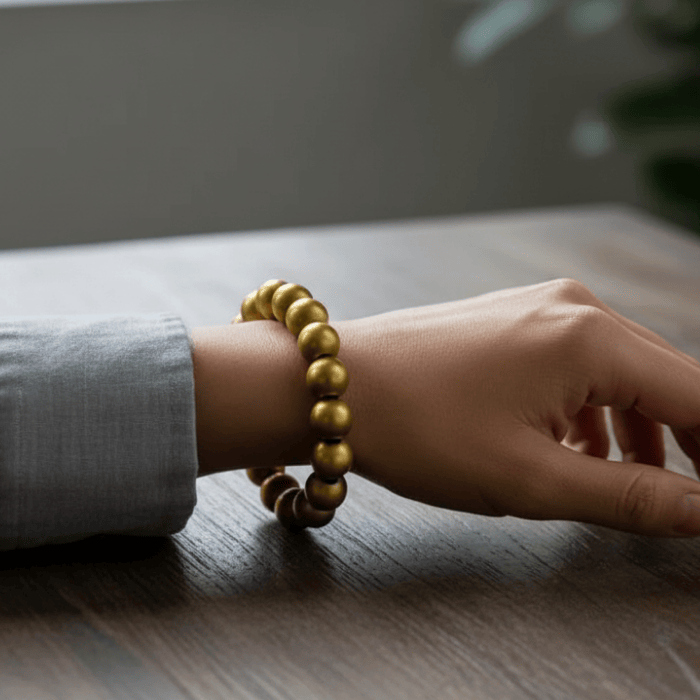 Genuine Golden Hematite Bracelet showcasing a stylish design on a wrist against a wooden background