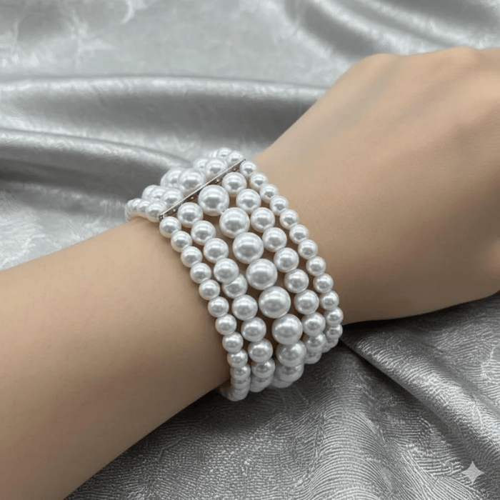 Multi Strand White Glass Pearl Stretch Bracelet elegantly displayed on a hand with a silky background