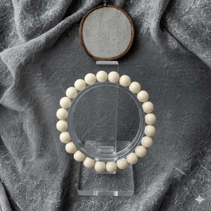 Red Coral and Cream Fossil Bracelet Set displayed elegantly on a clear stand against a textured background