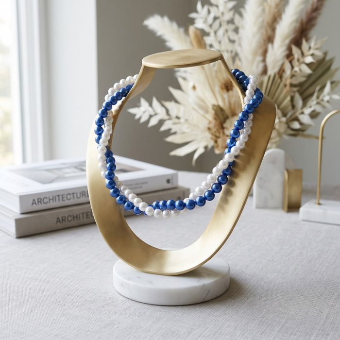 Elegant Royal Blue Pearl Twisted Necklace with white pearls displayed on a modern stand