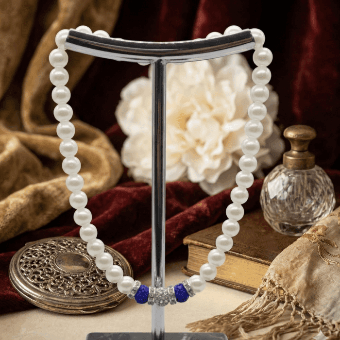 Royal Blue Rhinestone and White Glass Pearls Necklace displayed elegantly on a stand